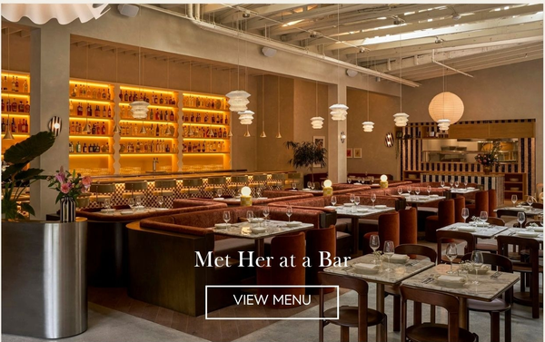 Met Her at a Bar dining room with velvet banquettes, marble tables, glowing back bar and paper lanterns, with a View Menu button