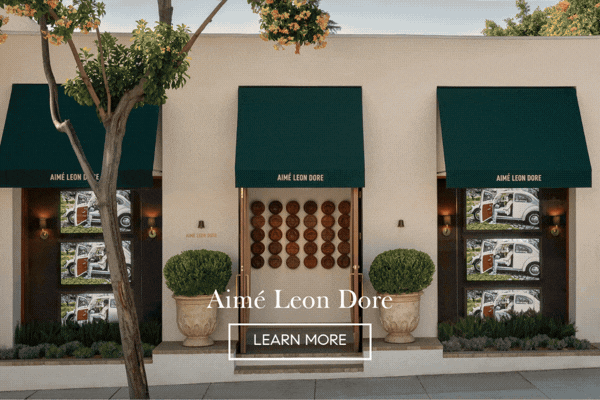 Animated image of the Aimé Leon Dore storefront on Melrose with dark green awnings and potted topiaries, 'Aimé Leon Dore' and a Learn More button
