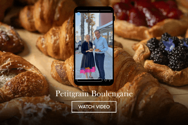 Animated image of croissants and berry pastries with a phone frame showing Diana and Frank outside Petitgrain, 'Petitgrain Boulengarie' with a Watch Video button